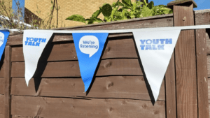 Youth Talk's bunting with some triangles showing our tag line 'we're listening' and others showing our logo.