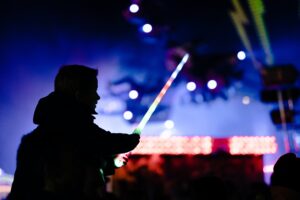 Fundraising at a concert: a young boy on an adults shoulders holding a glow stick